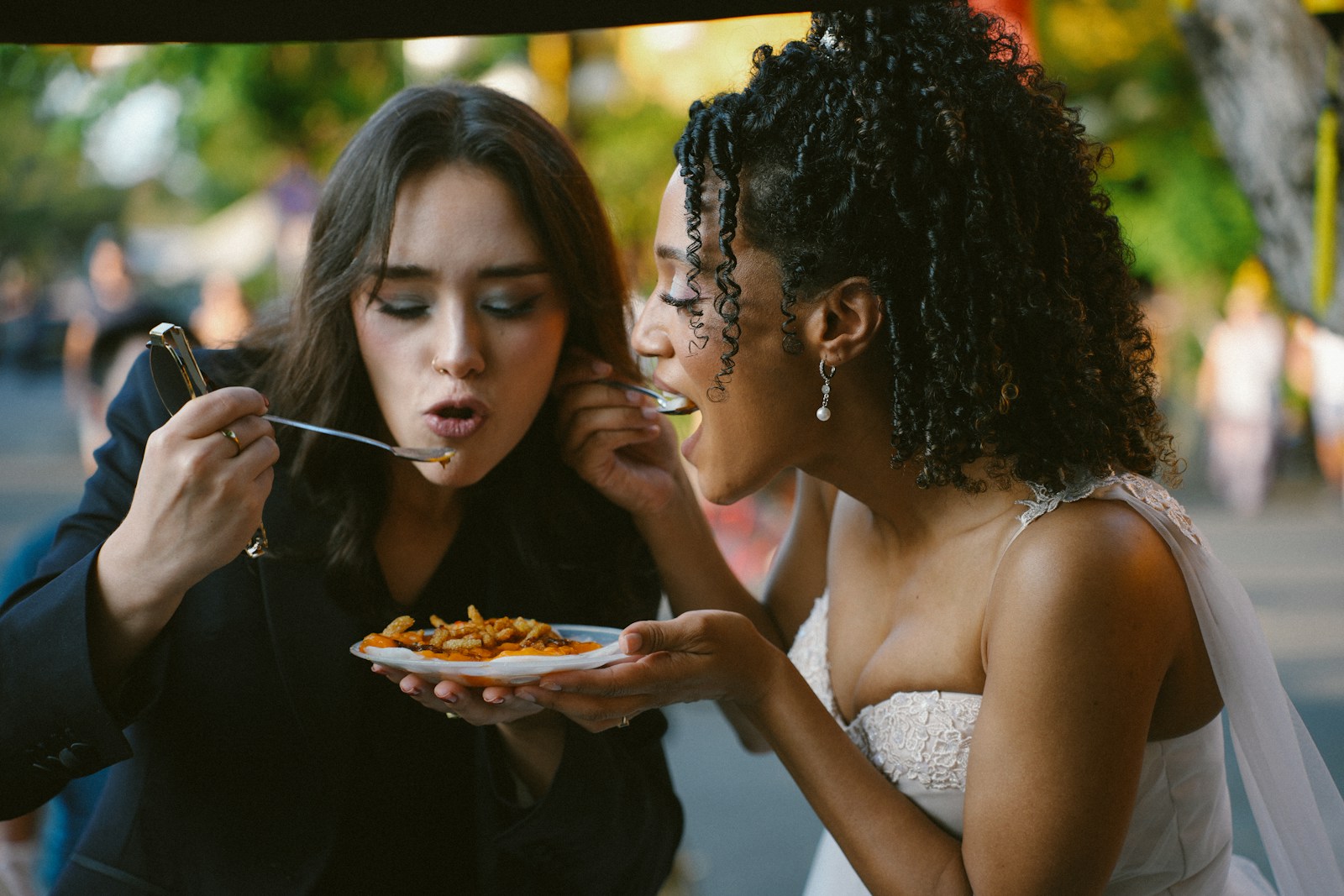 Two women sharing food from a plate
