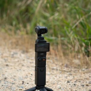 A black gimbal stabilizer with camera outdoors.